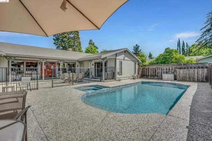 Integrated pool / spa with a patio and a fenced backyard