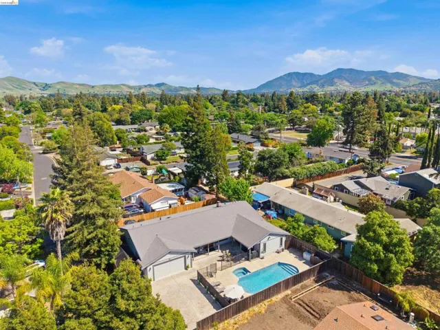 Aerial view of residential area featuring a mountainous background and a pool area