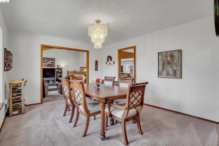 Dining room with light carpet and suspended lighting