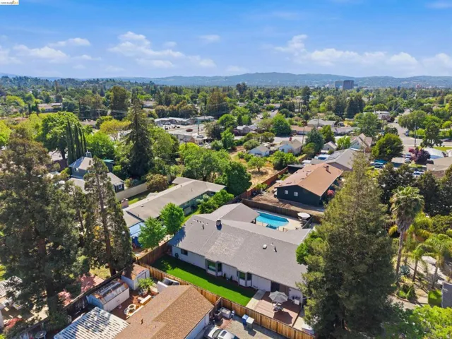 Aerial view of residential area featuring a mountainous background and a pool