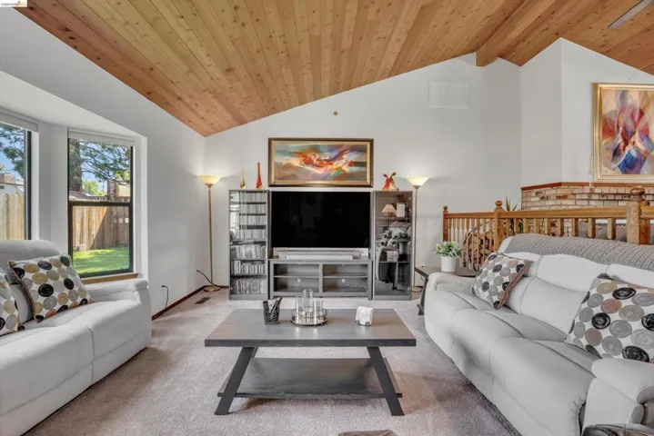 Living area featuring a vaulted wood ceiling and carpet floors