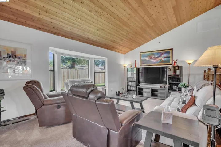 Living room with light carpet and a vaulted wooden ceiling