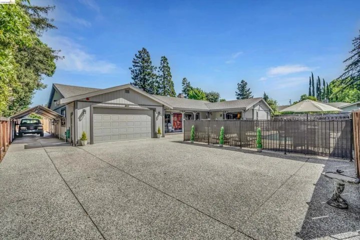 Ranch-style home featuring a garage and concrete driveway