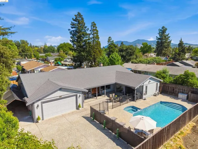 Integrated pool / hot tub with a fenced backyard, a patio, and a residential view
