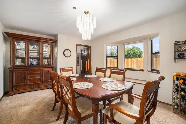 Dining room featuring light colored carpet and a chandelier