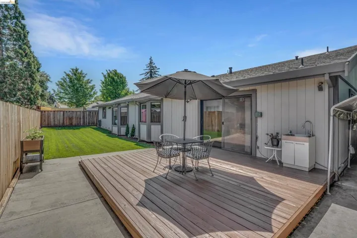 Wooden deck featuring outdoor dining space and a fenced backyard
