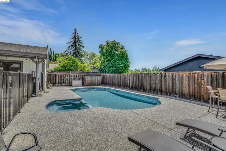 Integrated pool / spa featuring a patio area and a fenced backyard