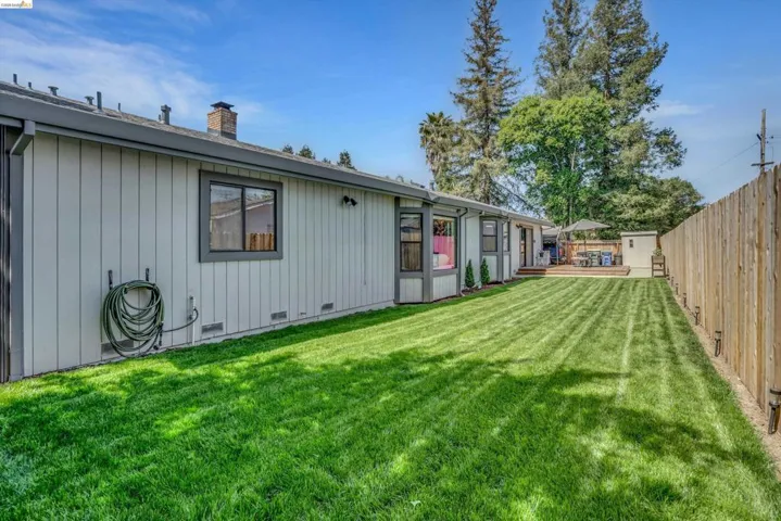 Rear view of property with a chimney, a fenced backyard, a deck, and crawl space