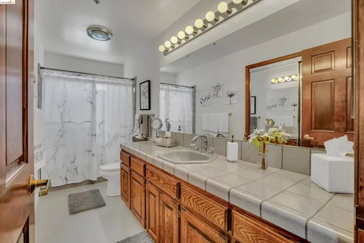Full bathroom featuring vanity, shower / tub combo, and finished concrete floors
