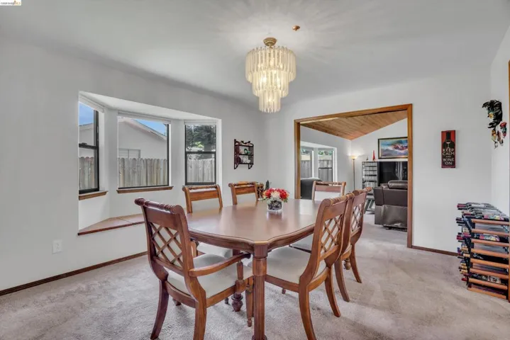 Dining area featuring hanging lights, light colored carpet, and a vaulted wood ceiling