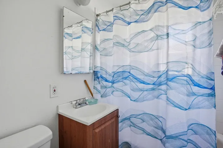 Full bathroom with vanity and curtained shower