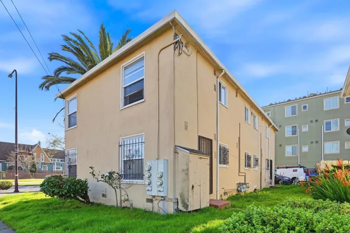 Back of property with stucco siding and a yard