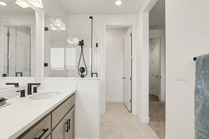 Full bathroom featuring a stall shower, vanity, and light tile patterned floors