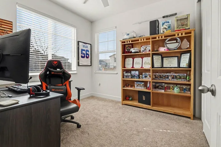 Office with light colored carpet and ceiling fan
