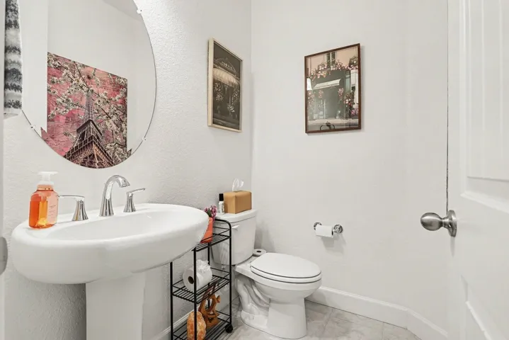 Bathroom featuring toilet and a textured wall