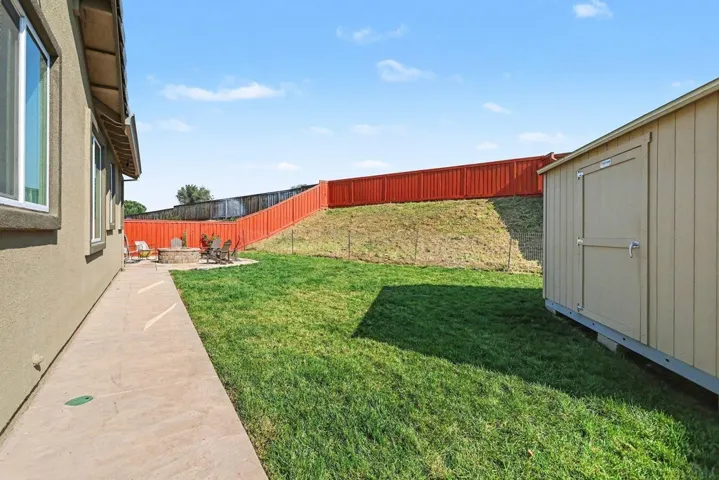 Fenced backyard with a patio and a shed