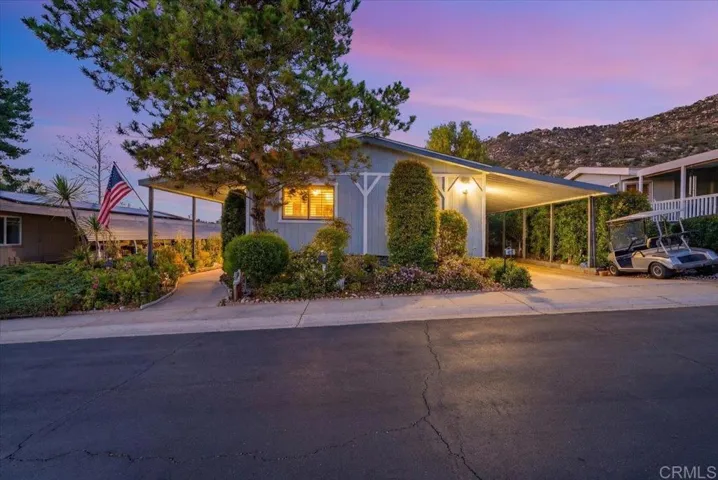 Front approach at dusk with curved driveway and soft exterior lighting.
