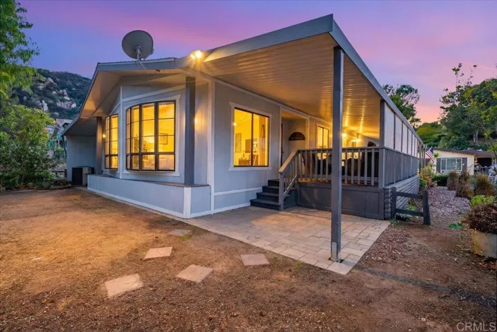 Evening exterior view with warm lighting and inviting patio stairs