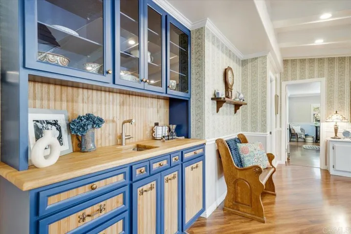 Built-in cabinetry and prep area with stylish blue accents and wood flooring.