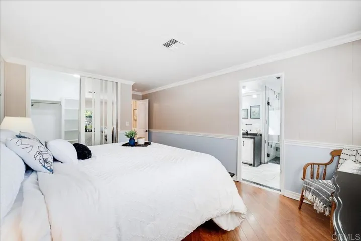 Alternate view of the primary bedroom with seating area and natural light.