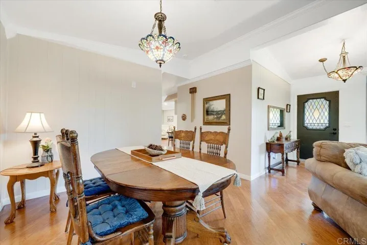 Dining area with classic chandelier, hardwood flooring, and easy flow to living spaces.