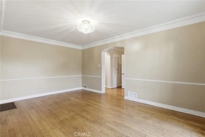 Formal Dining with Arched doorways, hardwood floors, crown moldings