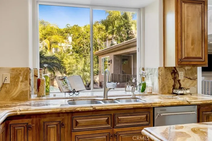 Looking out the kitchen sink window onto the backyard, pool and one of the casitas