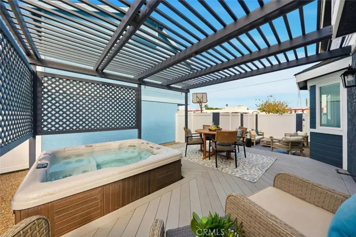 Trellis covered patio with spa, deck, and outdoor furniture