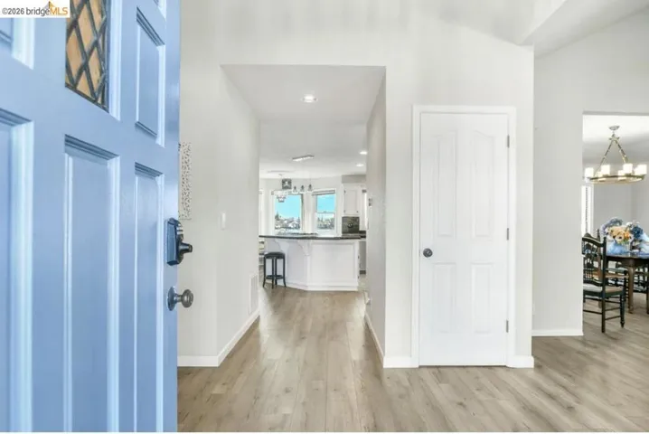 Foyer with light wood finished floors and a chandelier