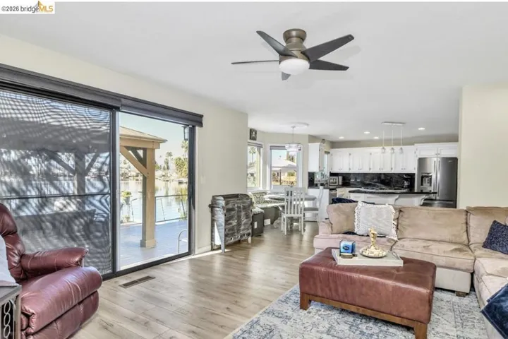 Living area with ceiling fan, light wood finished floors, and recessed lighting