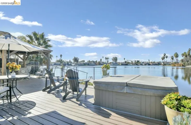 Dock featuring a hot tub, a gazebo, and a deck with water view