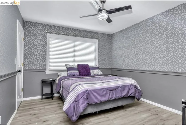 Bedroom with light wood finished floors and a ceiling fan
