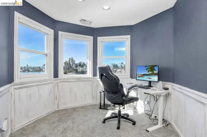 Carpeted office space with wainscoting and a decorative wall