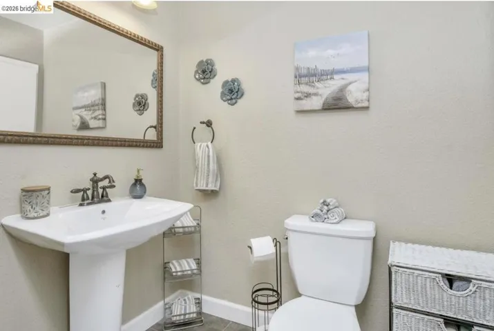 Half bath featuring toilet and baseboards