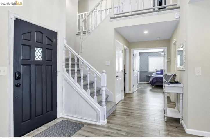 Entryway featuring light wood-style flooring, recessed lighting, and a high ceiling