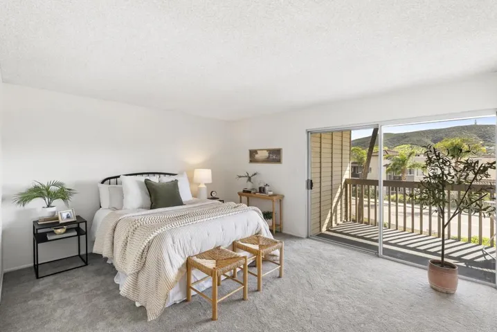 Primary bedroom with another large slider onto your own private balcony with views of the hills