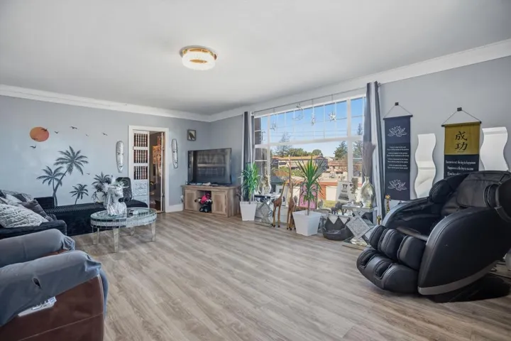Living room featuring wood finished floors and crown molding