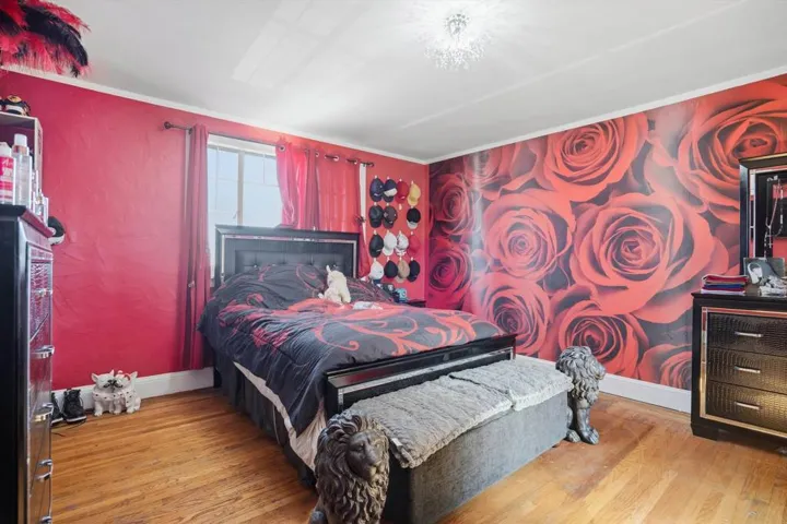 Bedroom with wood-type flooring and crown molding