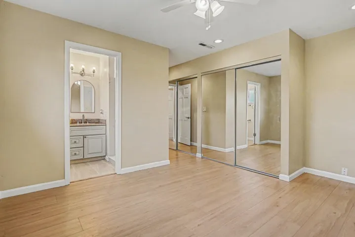 Unfurnished bedroom with a closet, light wood finished floors, a ceiling fan, connected bathroom, and recessed lighting