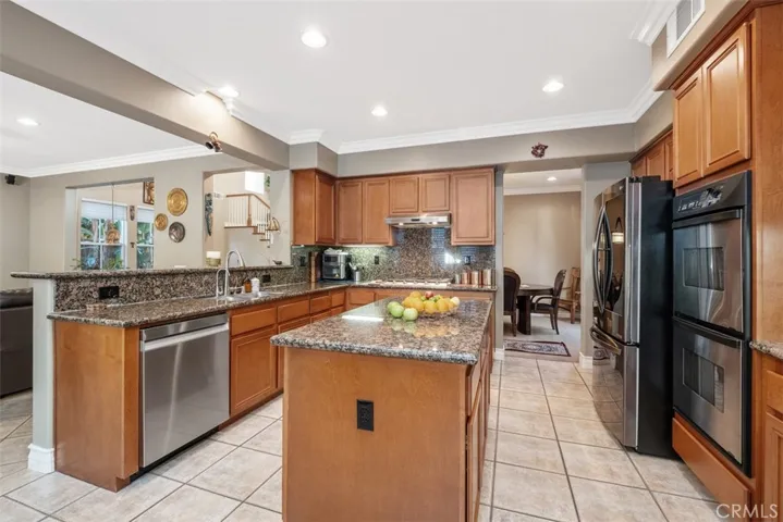 Upgraded kitchen with double ovens, stainless steel appliances and island.