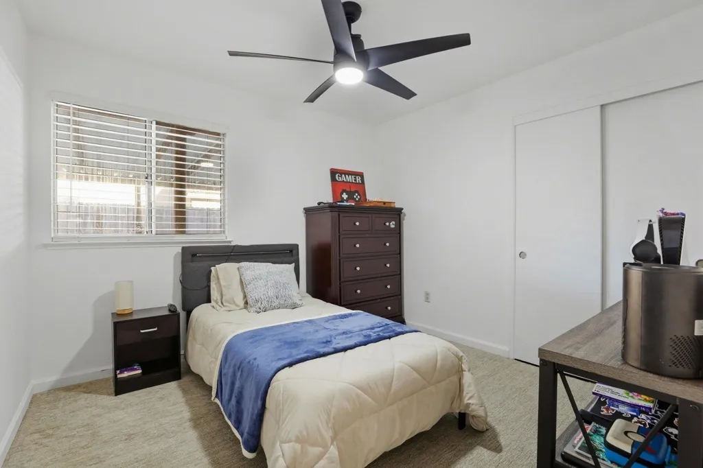 Bedroom featuring light colored carpet, a closet, and ceiling fan