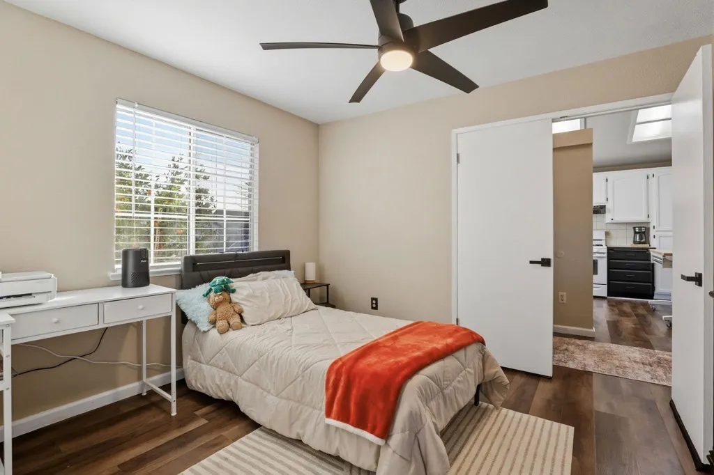 Bedroom with dark wood-type flooring and a ceiling fan