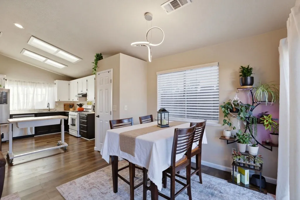 Dining room featuring lofted ceiling and dark wood-style flooring