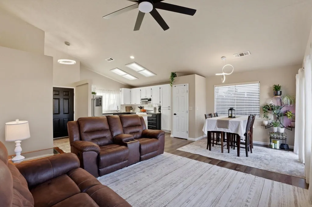 Living area featuring a ceiling fan, wood finished floors, lofted ceiling, plenty of natural light, and recessed lighting