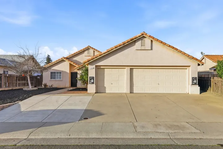 Mediterranean / spanish-style home with stucco siding, a tiled roof, driveway, and a garage