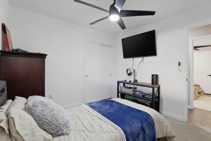 Bedroom with carpet flooring, ceiling fan, and a closet