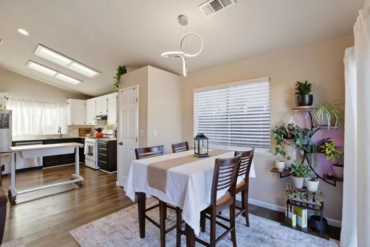 Dining room featuring lofted ceiling and dark wood-style flooring