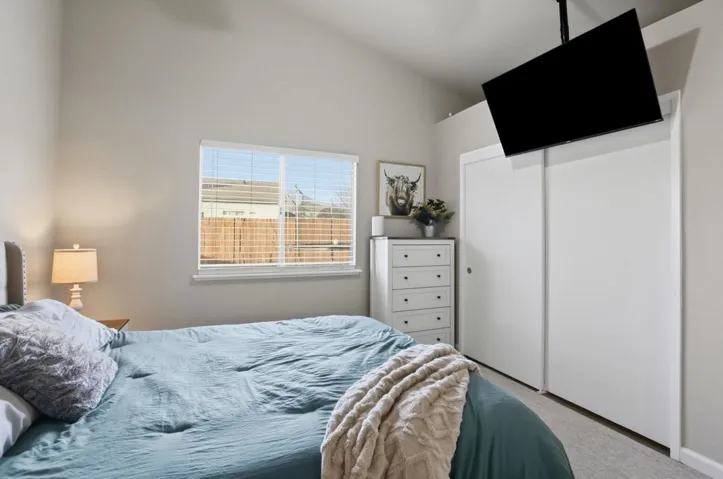 Carpeted bedroom featuring a closet and vaulted ceiling