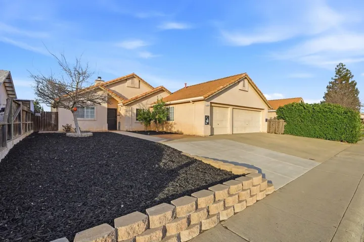 View of front of home featuring stucco siding, concrete driveway, a garage, a tiled roof, and a chimney