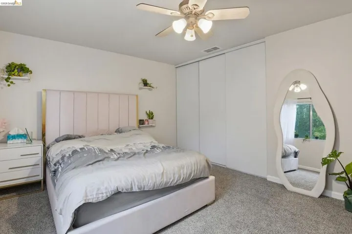 Carpeted bedroom featuring a ceiling fan and baseboards